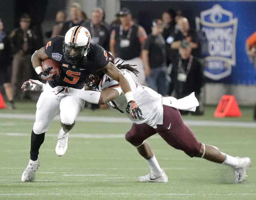 Oklahoma State running back Justice Hill (5) tries to get past Virginia Tech linebacker...