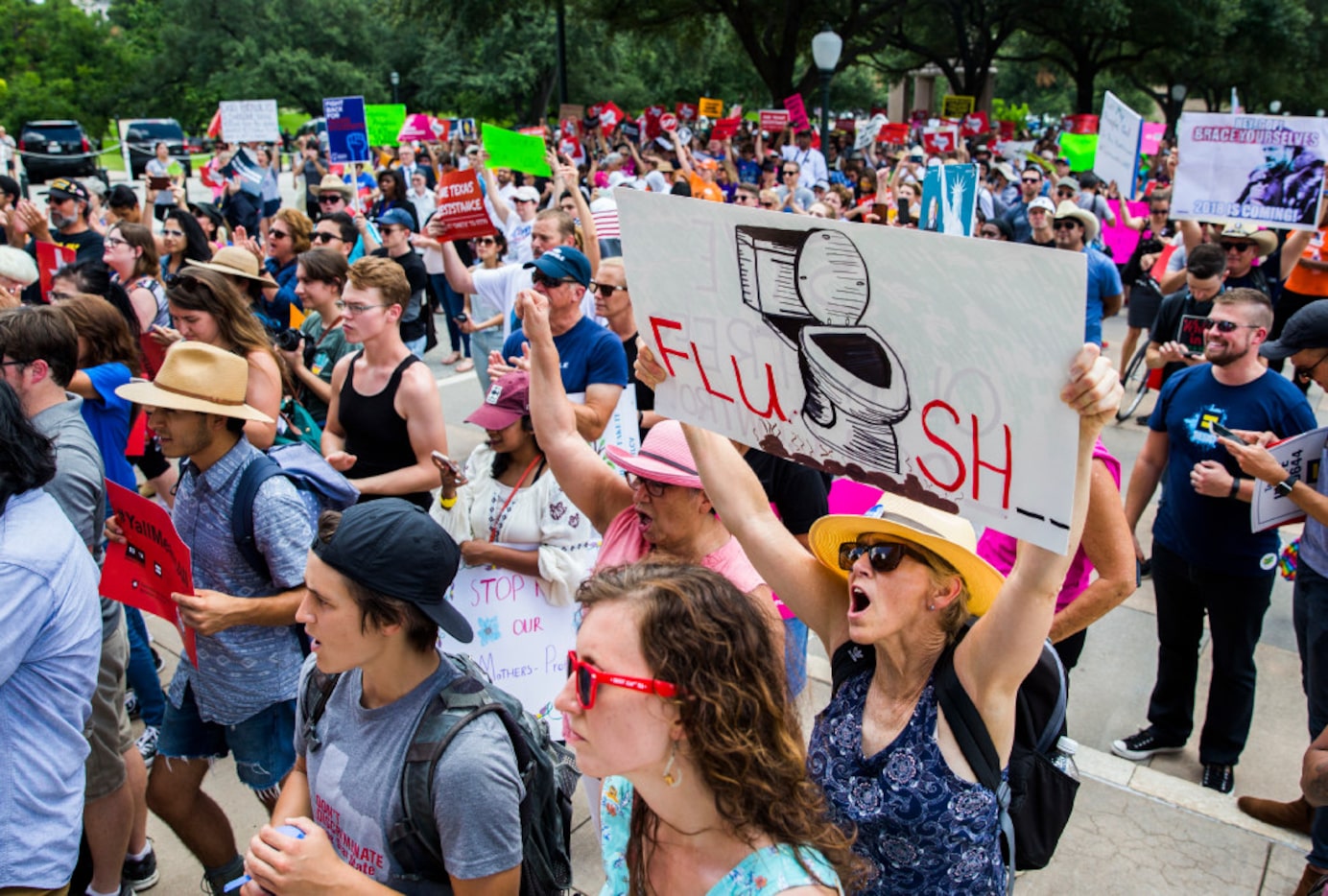 A protester held up a sign while chanting during a One Texas Resistance rally on the south...