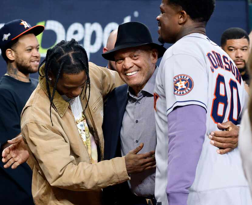 Rapper Travis Scott (left) is greeted by Hall of Fame baseball player Reggie Jackson...