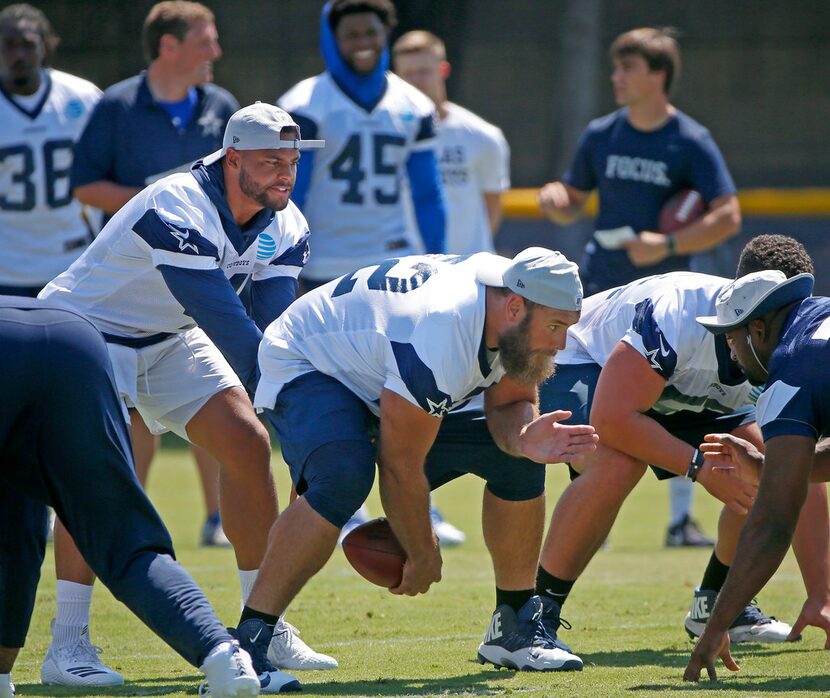 Dallas Cowboys quarterback Dak Prescott (4) takes a snap from center Travis Frederick (72)...