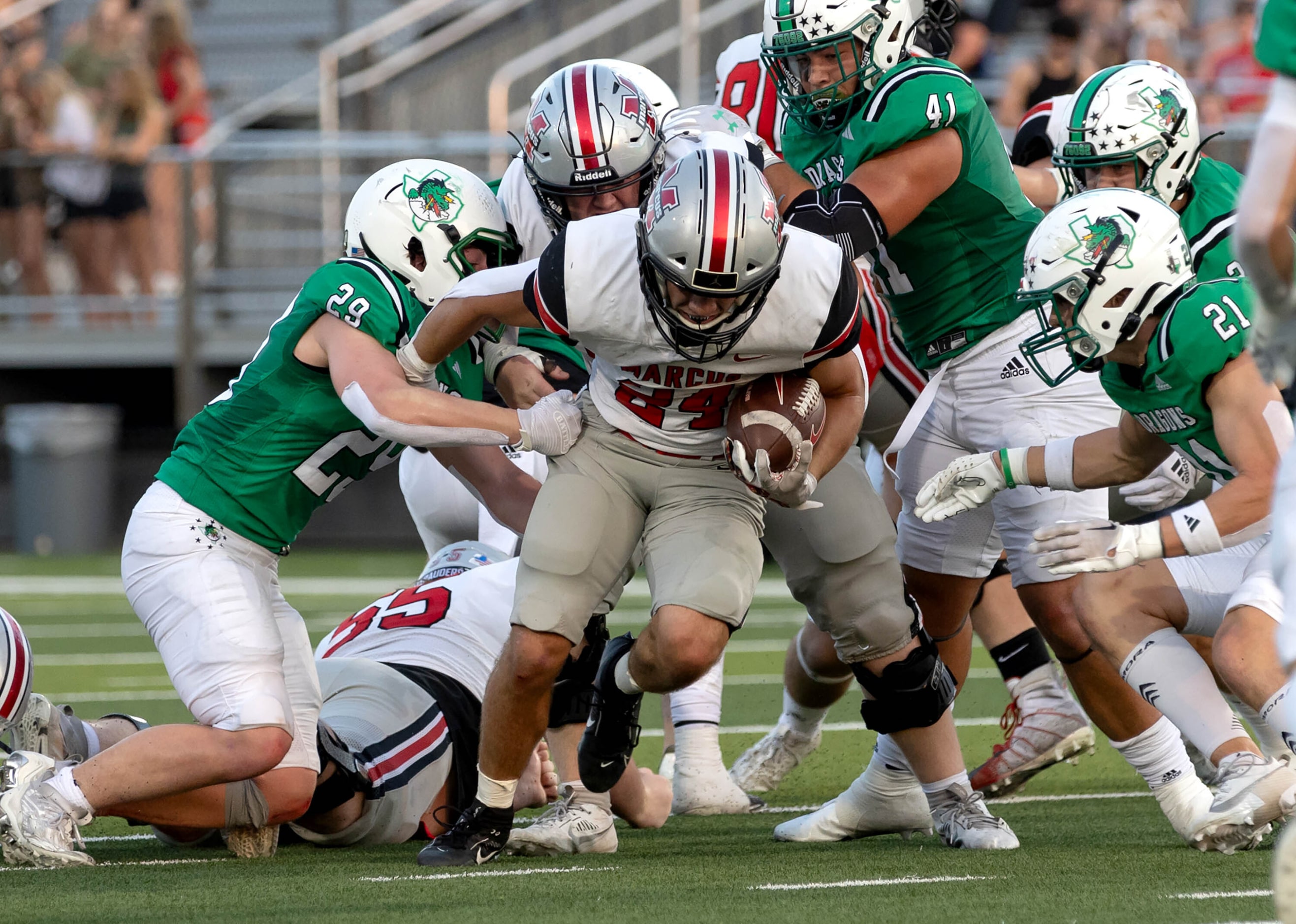 Flower Mound Marcus running back Isaiah Keliikipi (24) tries to break free against Southlake...