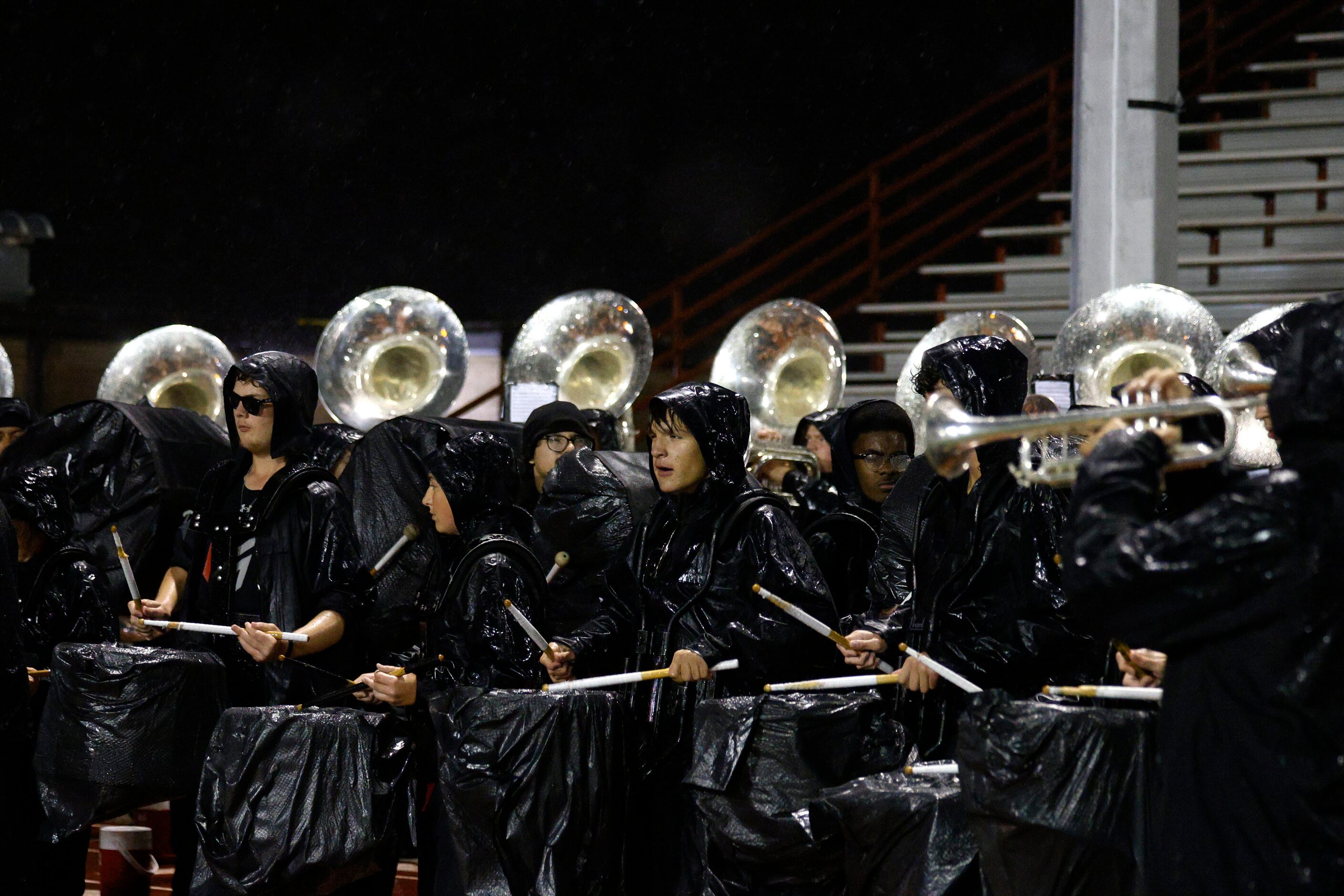 Martin marching band members play in the rain during the second half of a high school Class...