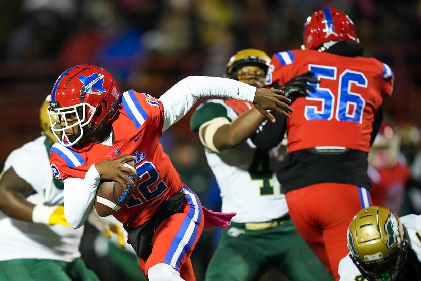 Duncanville quarterback Keelon Russell (12) scrambles away from the DeSoto pass rush during...