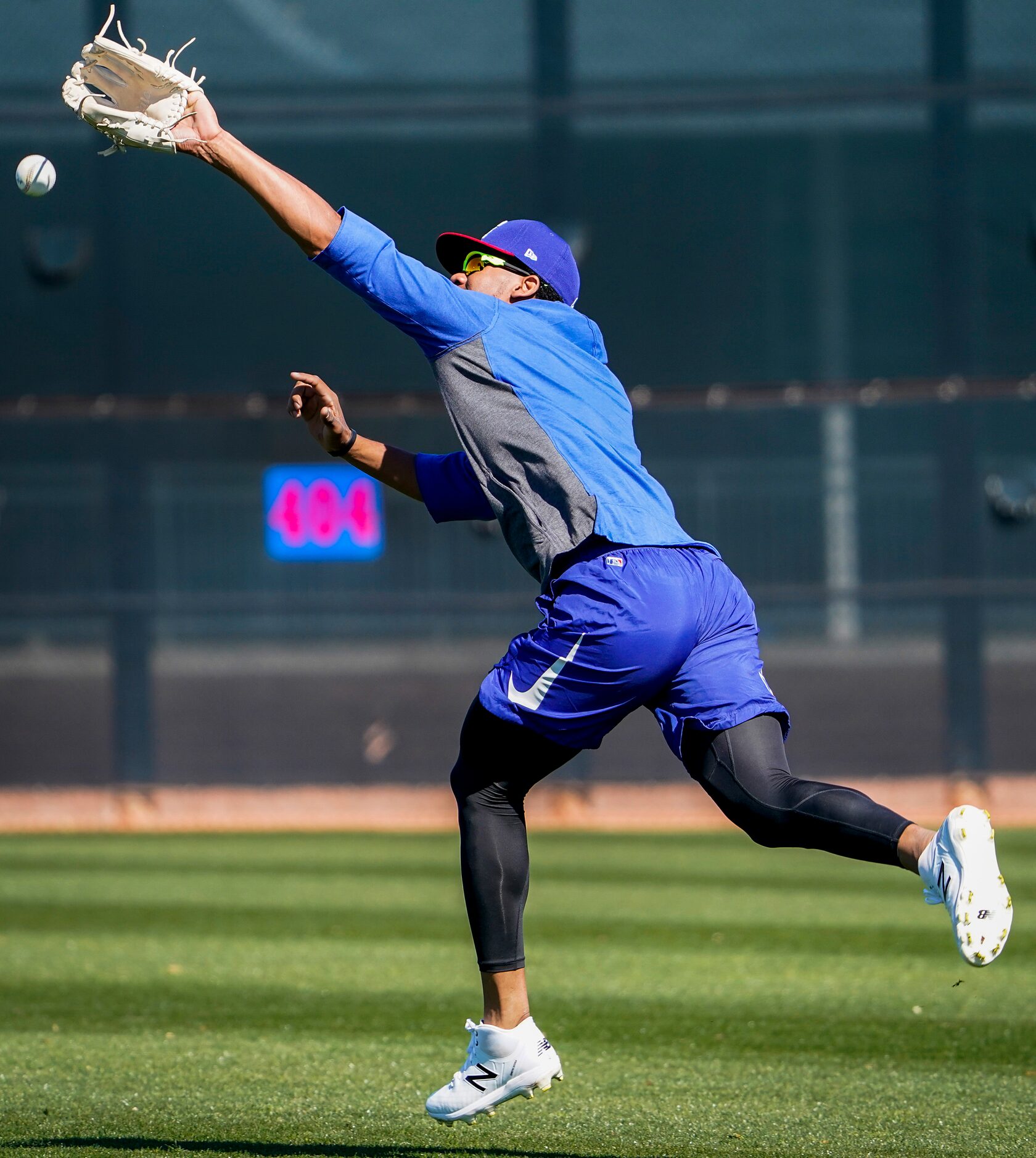 Texas Rangers outfielder Leody Taveras has a ball go just out of reach while participating...