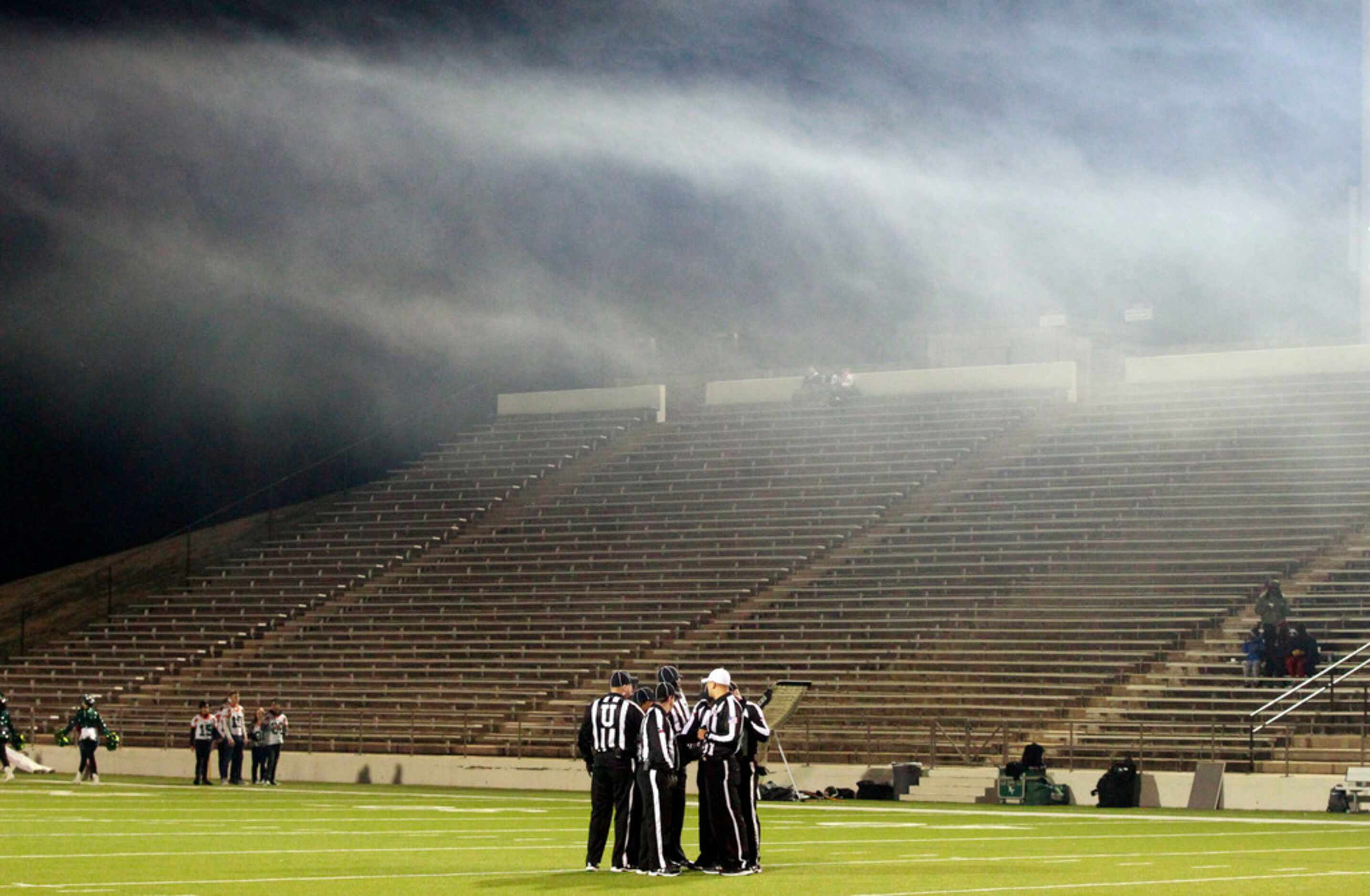 Games officials confer under a cloud of smoke before the start of the Naaman Forest Vs....