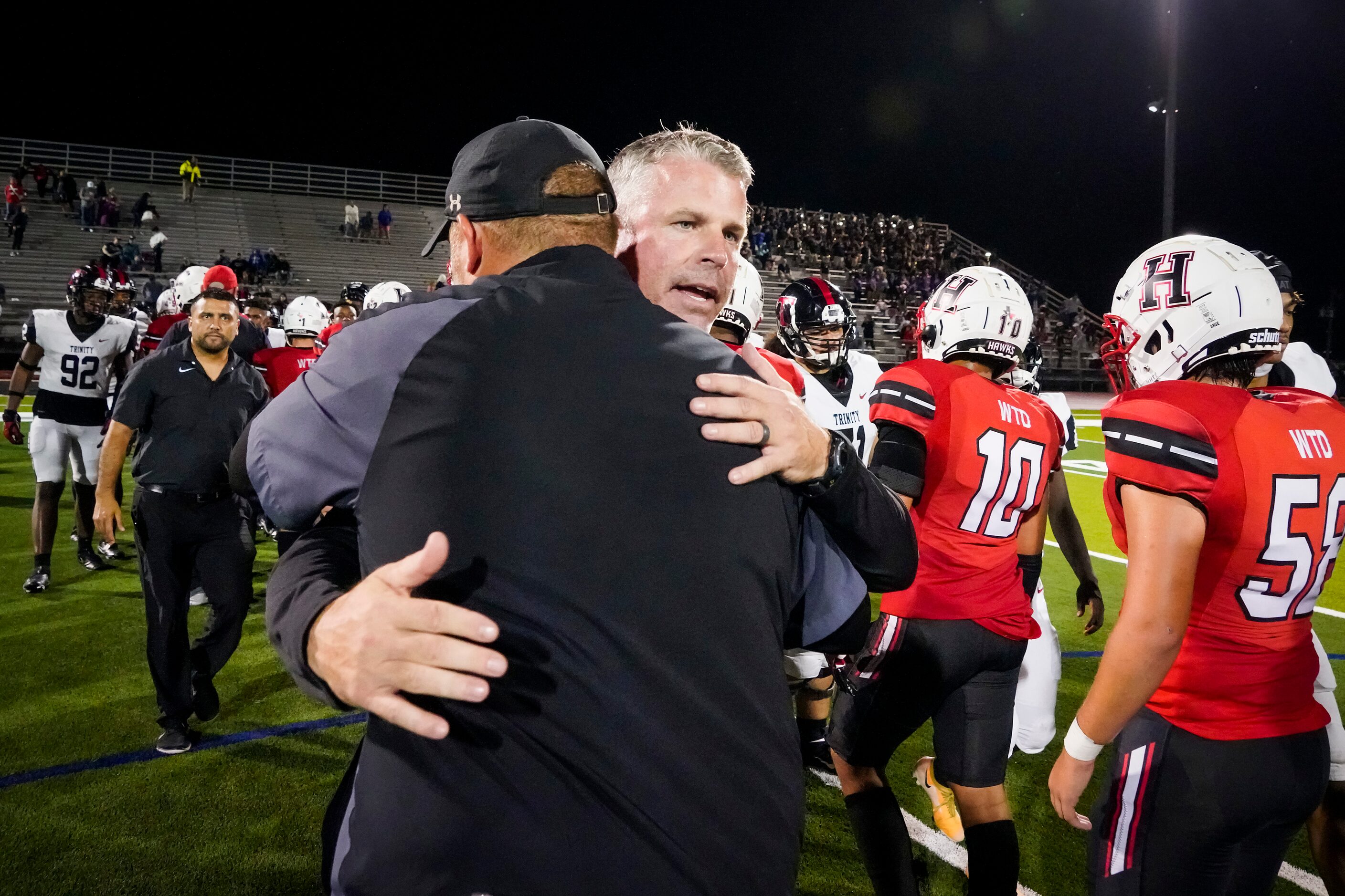 Euless Trinity head coach Aaron Lineweaver hugs Rockwall-Heath head coach John Harrell after...