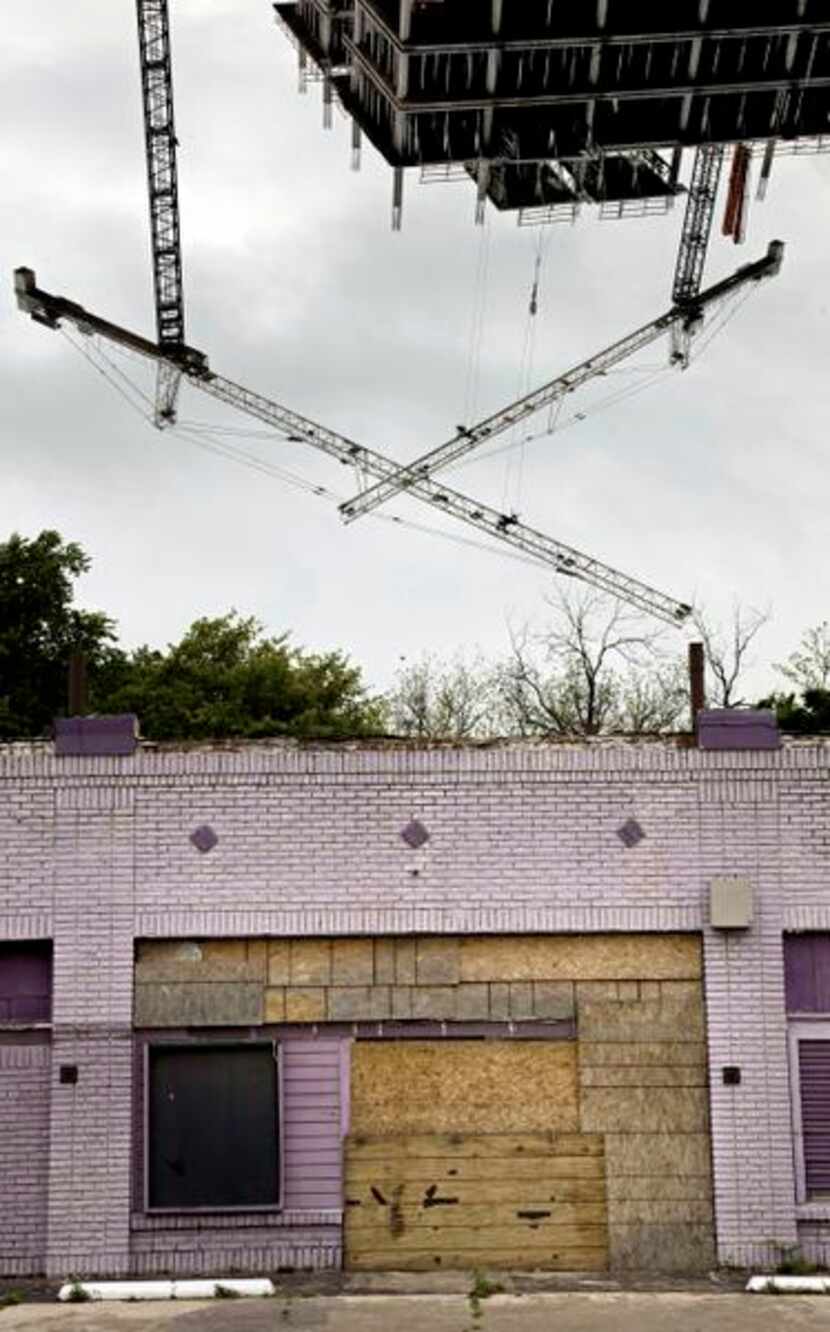 
An abandoned business in South Dallas decays in the shadow of a new building under...