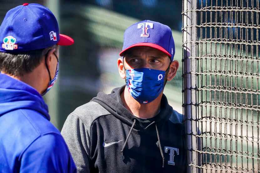 Texas Rangers manager Chris Woodward talks with bench coach Don Wakamatsu before of a spring...