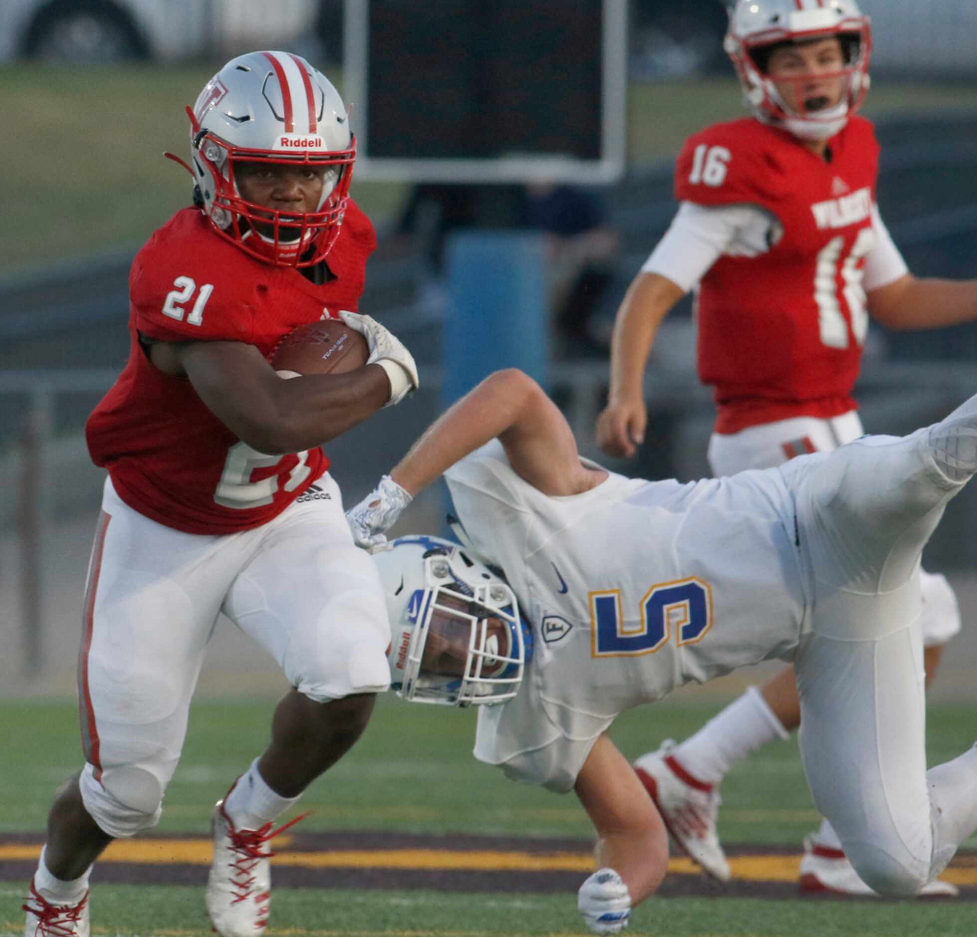 Dallas Woodrow Wilson running back Matthew Jackson (21) cuts upfield after avoiding the...