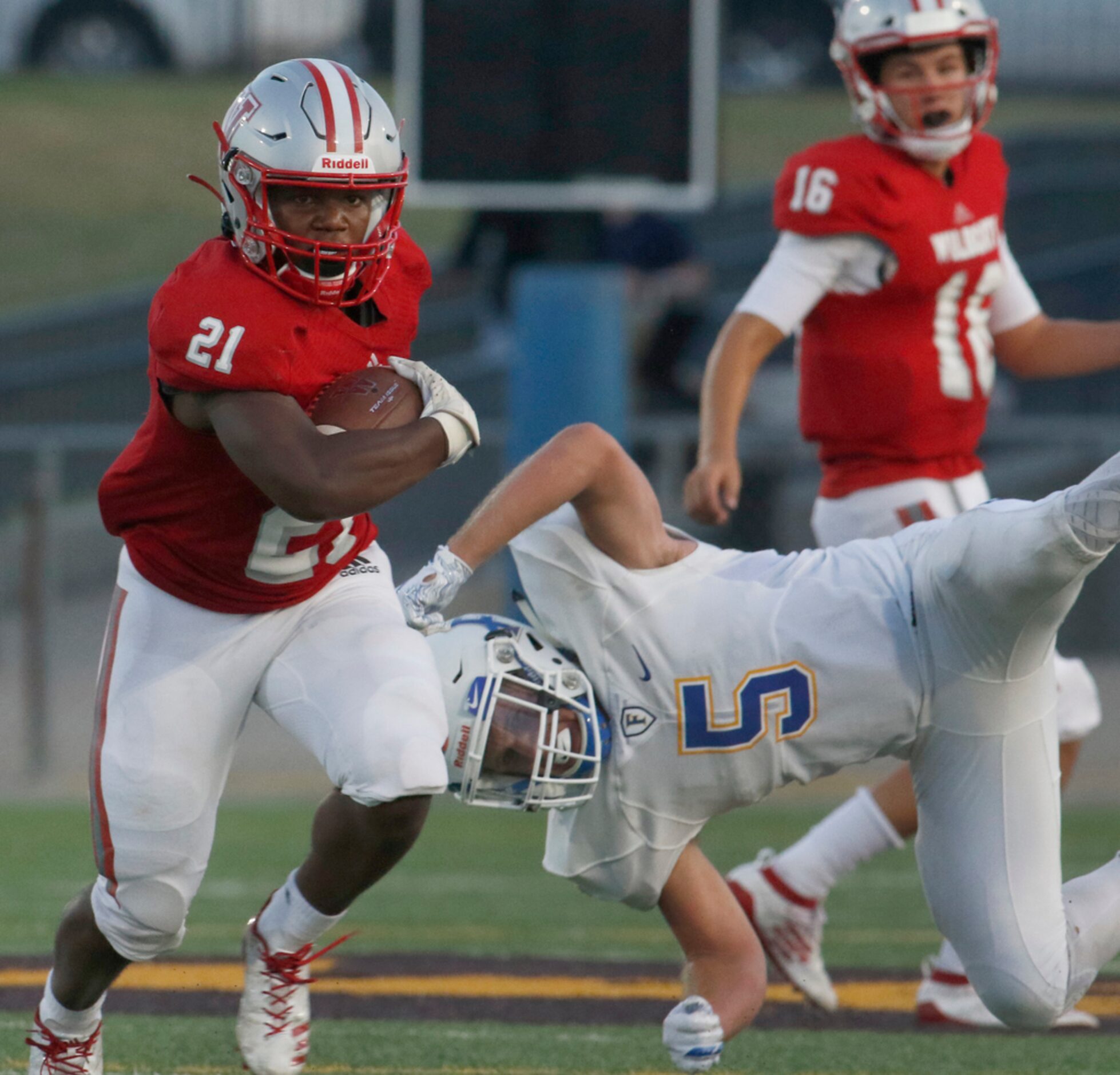 Dallas Woodrow Wilson running back Matthew Jackson (21) cuts upfield after avoiding the...