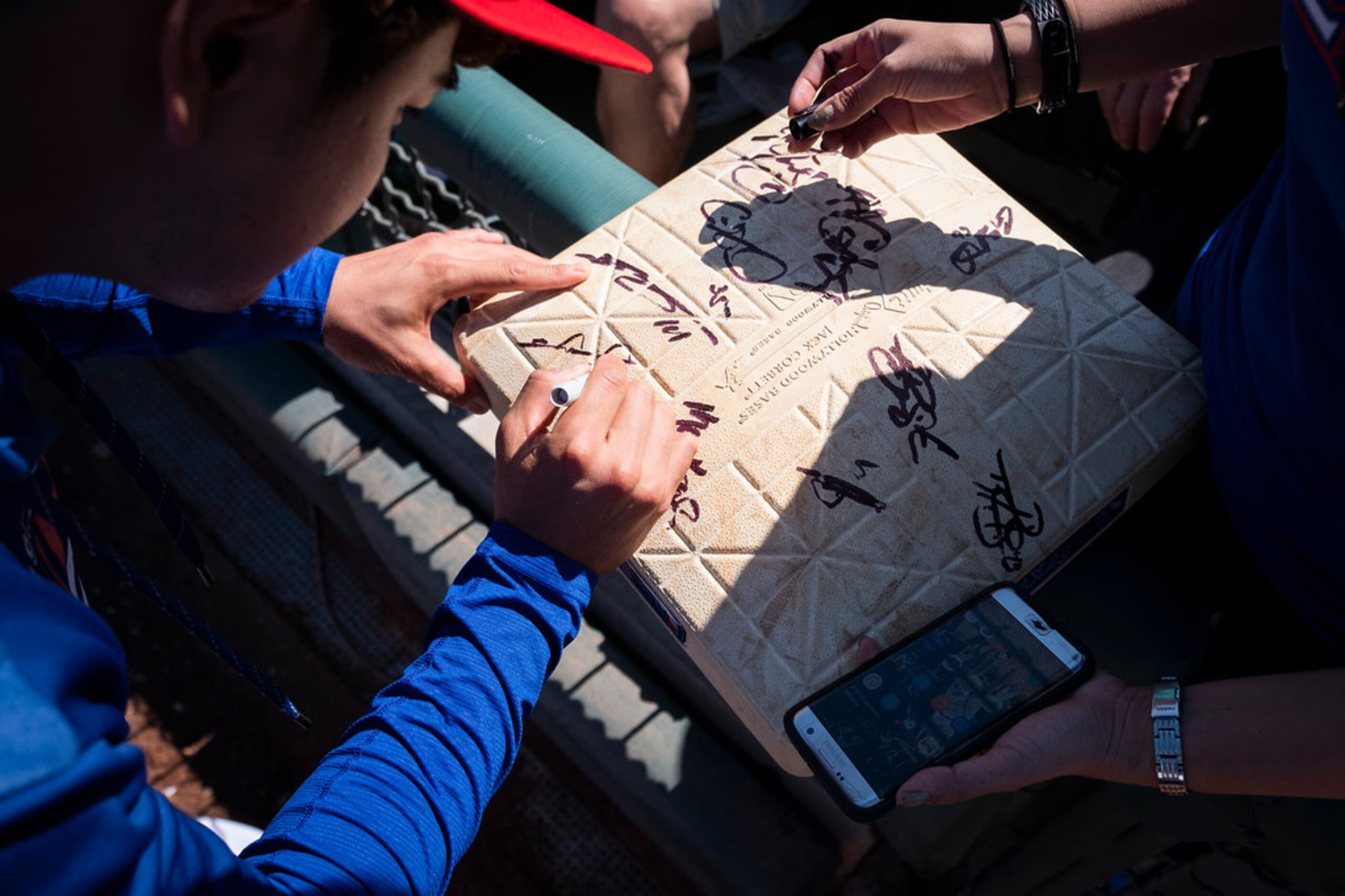 Texas Rangers outfielder Shin-Soo Choo autographs a base for a fan before a spring training...