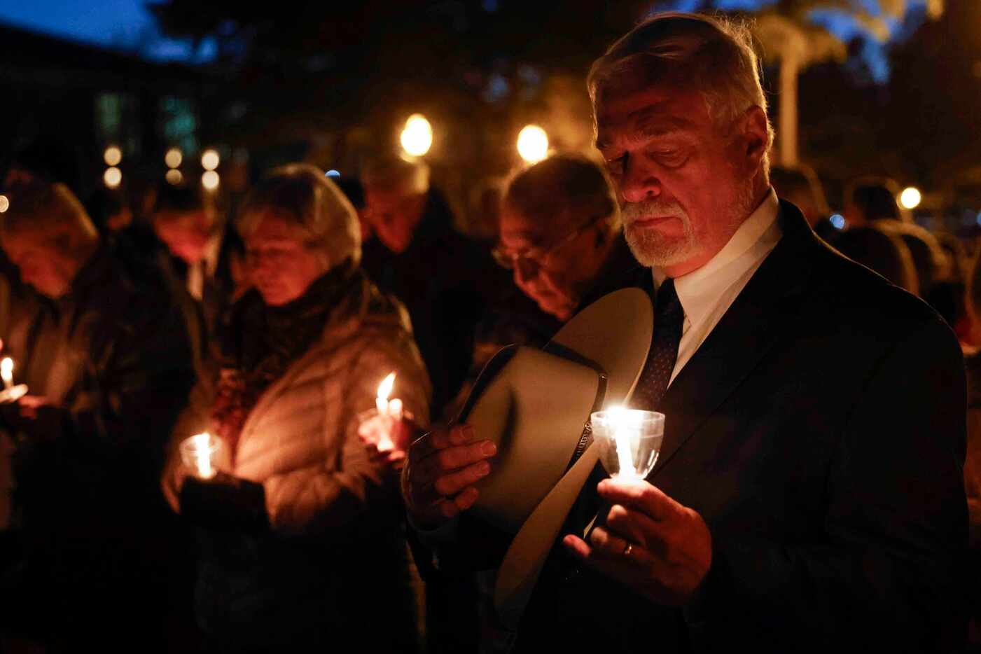 Steve Trine of Keller alongside others participate during a candle light vigil at Keller...