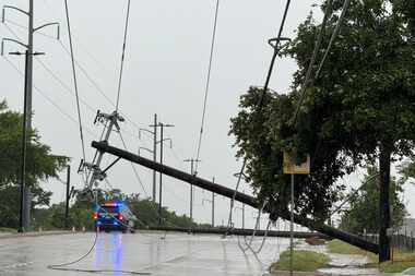 Garland police block traffic due to a downed power line on May 28 in Garland. Strong storms...
