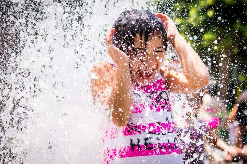 Melissa Castillo, 8, played in a fountain at Klyde Warren Park in Dallas on the first day of...