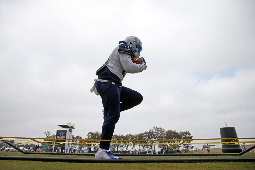 Dallas Cowboys running back Ezekiel Elliott runs through a drill during afternoon practice...