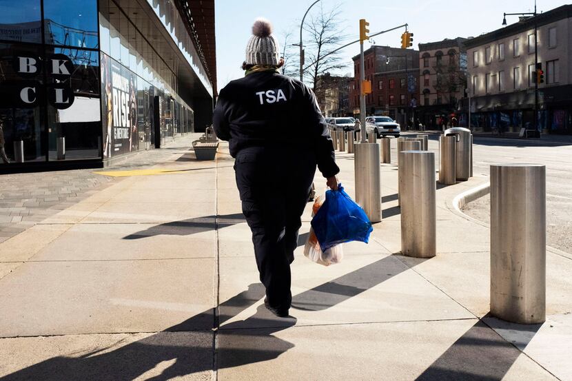 TSA worker Amelia Williams carries groceries from a food bank for government workers...