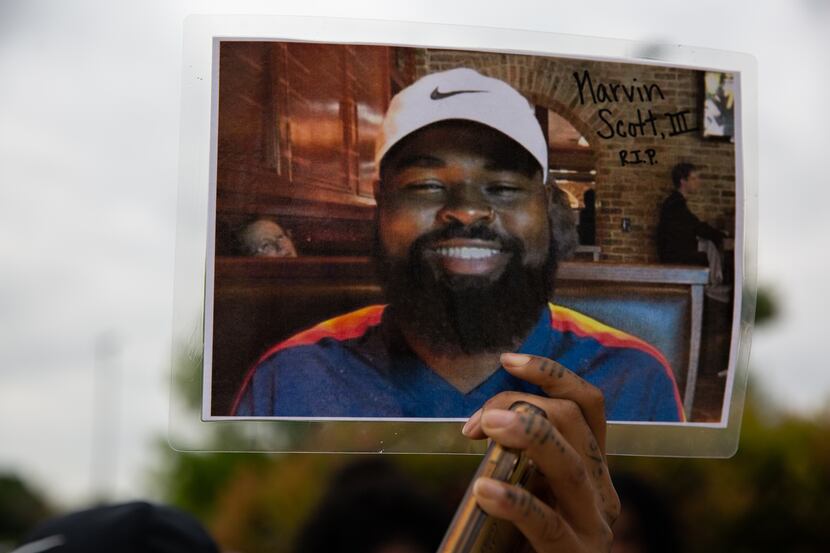 Renee White held up a photo of Marvin Scott III after a news conference on April 28, 2021,...