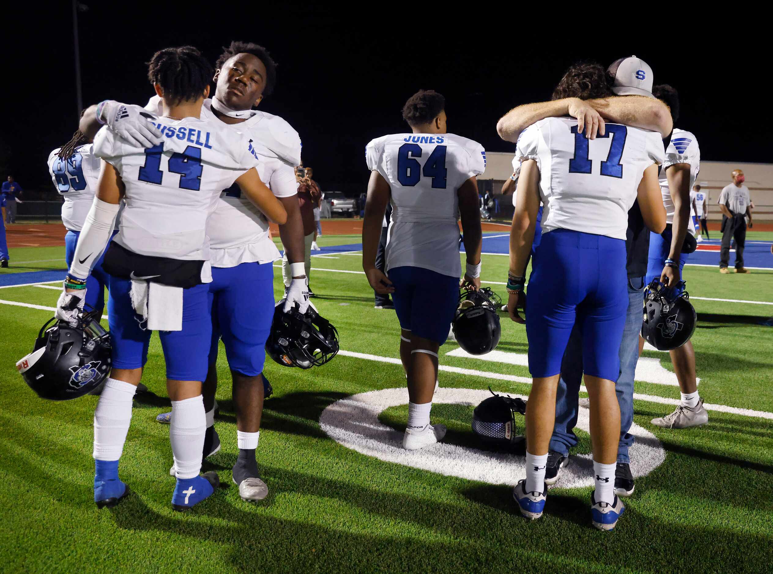 Mansfield Summit football players including Kobe Russell (14) receiving a hug from Andrew...
