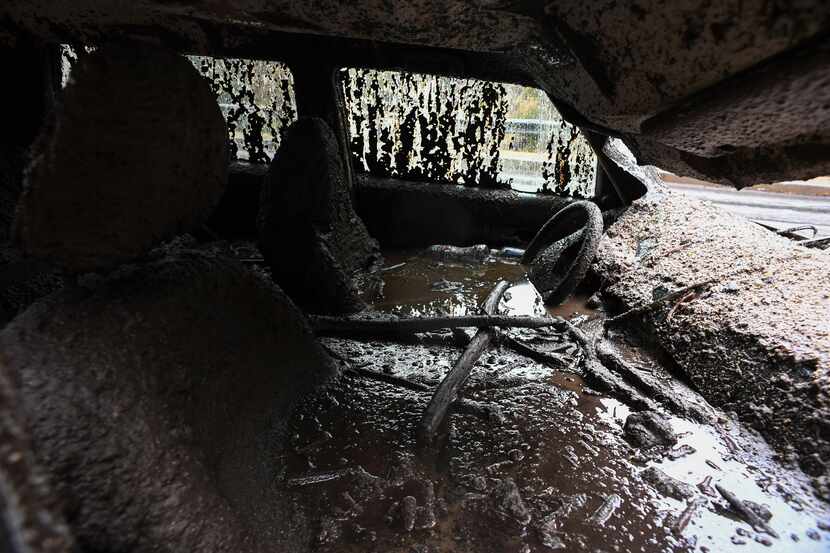 Mud fills the interior of a car destroyed in a rain-driven mudslide in a neighborhood under...