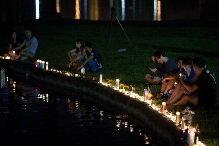  ORLANDO, FL - JUNE 12: People sit on the edge of Lake Eola, where candles were placed for...