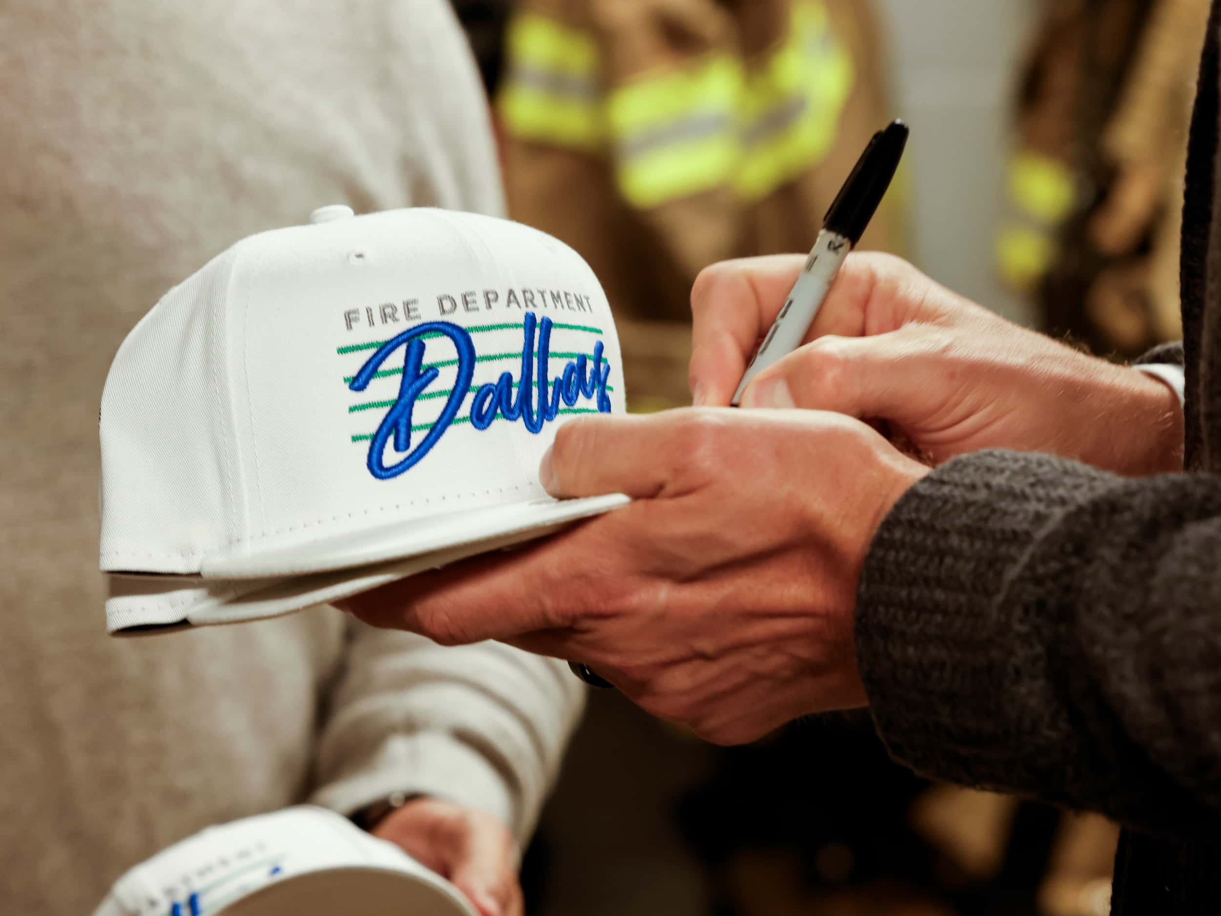 Dallas Mavericks Hall of Famer Dirk Nowitzki signs a special Dallas Fire-Rescue cap before...