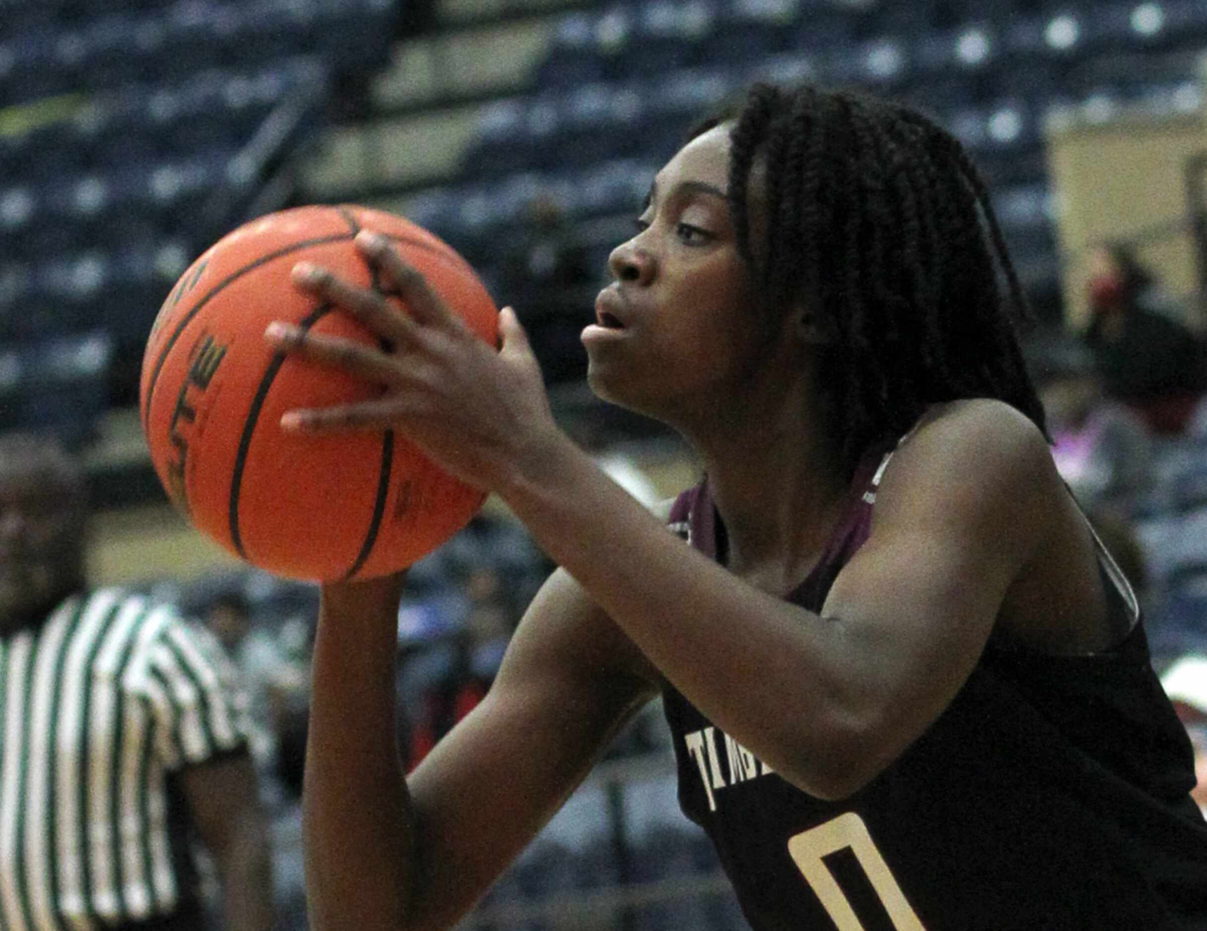 Mansfield Timberview's Stephanie Mosley (0) eyes the basket before putting up a three point...