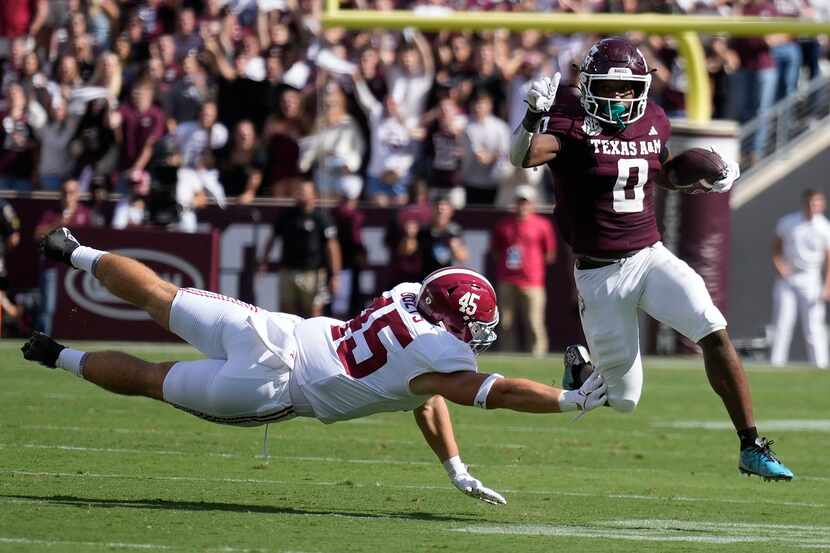 Texas A&M wide receiver Ainias Smith (0) breaks a tackle attempt by Alabama tight end Robbie...