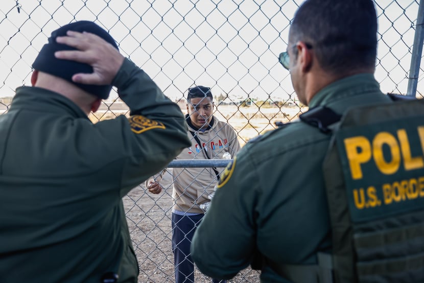 Rojas, a migrant from Peru, talks with Border Patrol agents as he tries to cross into the...