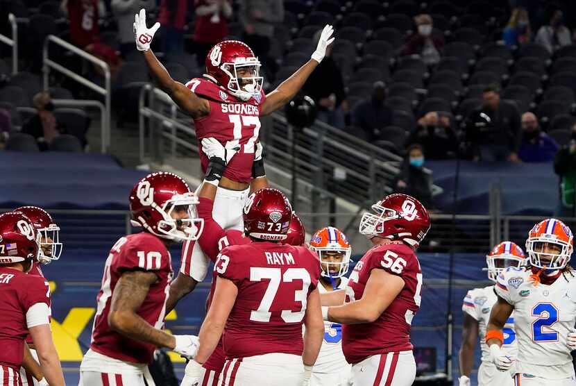 Oklahoma wide receiver Marvin Mims (17) celebrates with offensive lineman Tyrese Robinson...