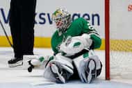 Dallas Stars goaltender Jake Oettinger (29) slowly gets up after a collision during the...