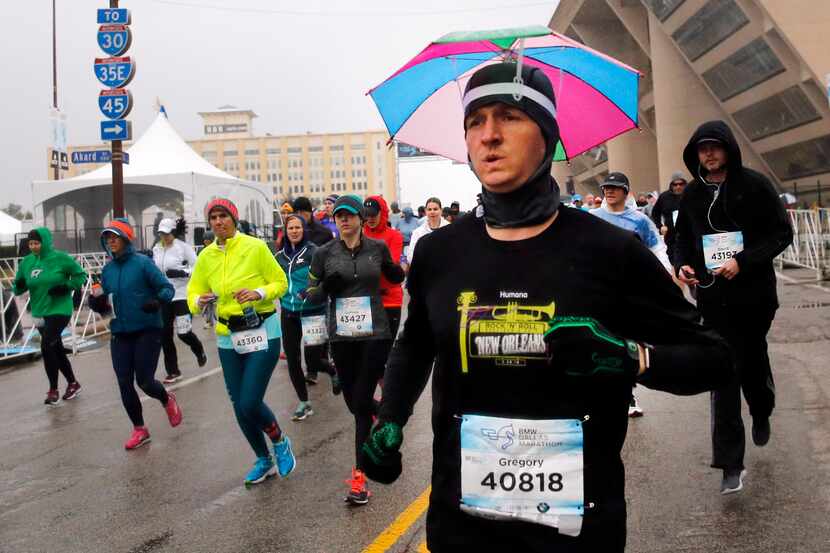 Runner Gregory Thompson of New Orleans kept his head dry with an umbrella as he competed in...