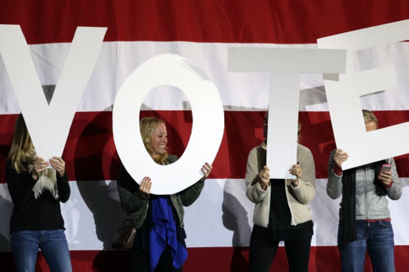 Women held up letters spelling "VOTE" before a campaign rally by President Barack Obama in...