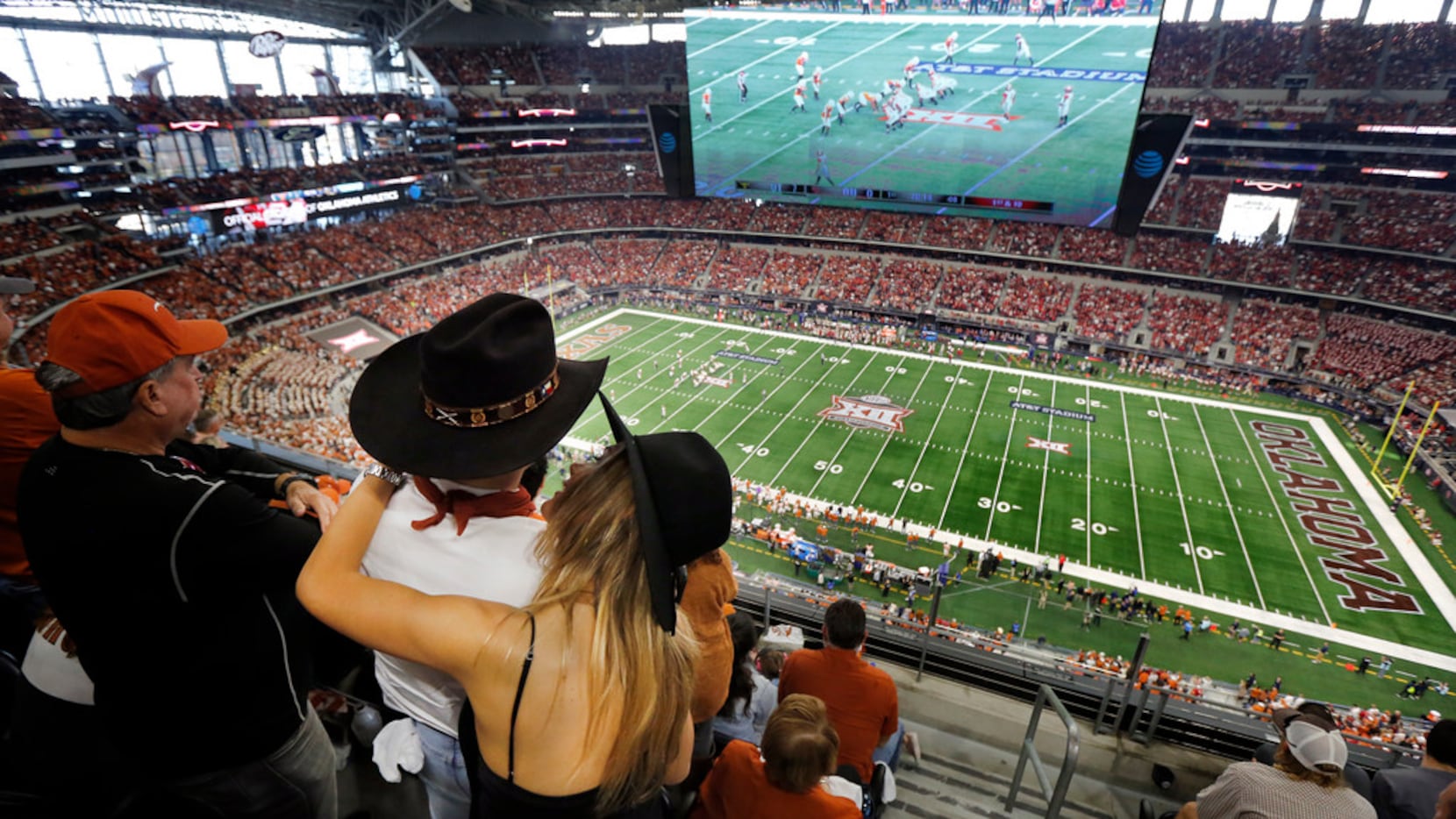 A Texas Longhorn couple embrace during the Big XII Championship game at AT&T Stadium in...