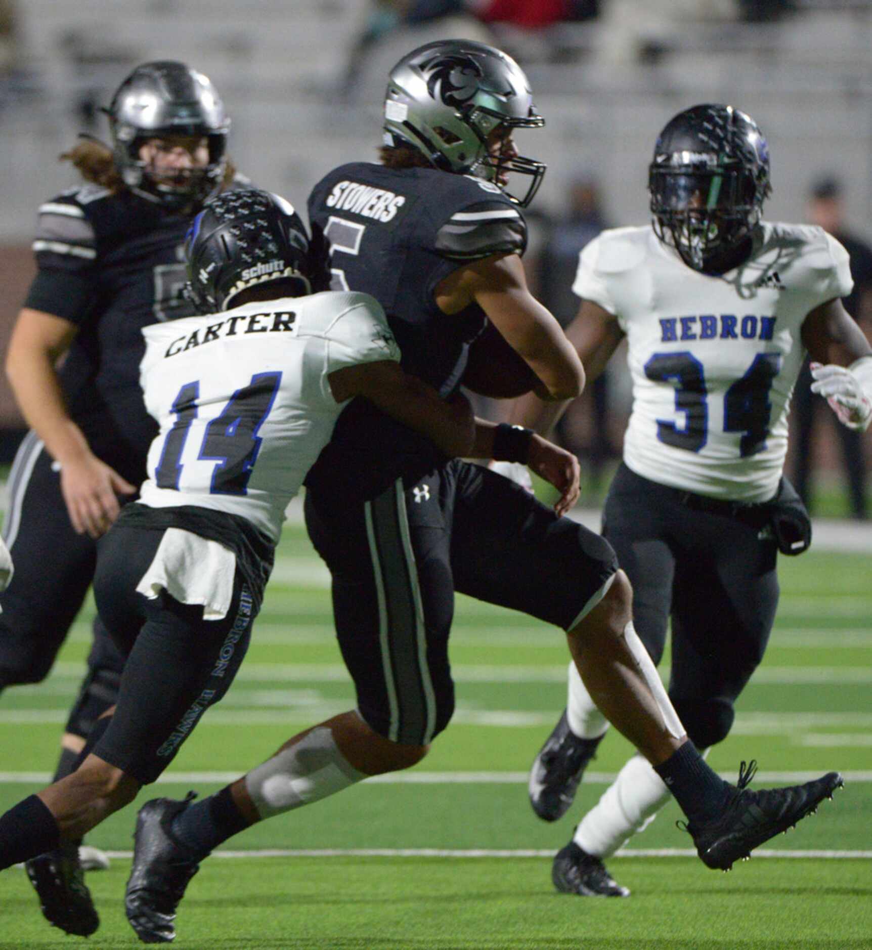 Guyer's Eli Stowers (5) is tackled by Hebron's Kayden Carter in the first half of a Class 6A...