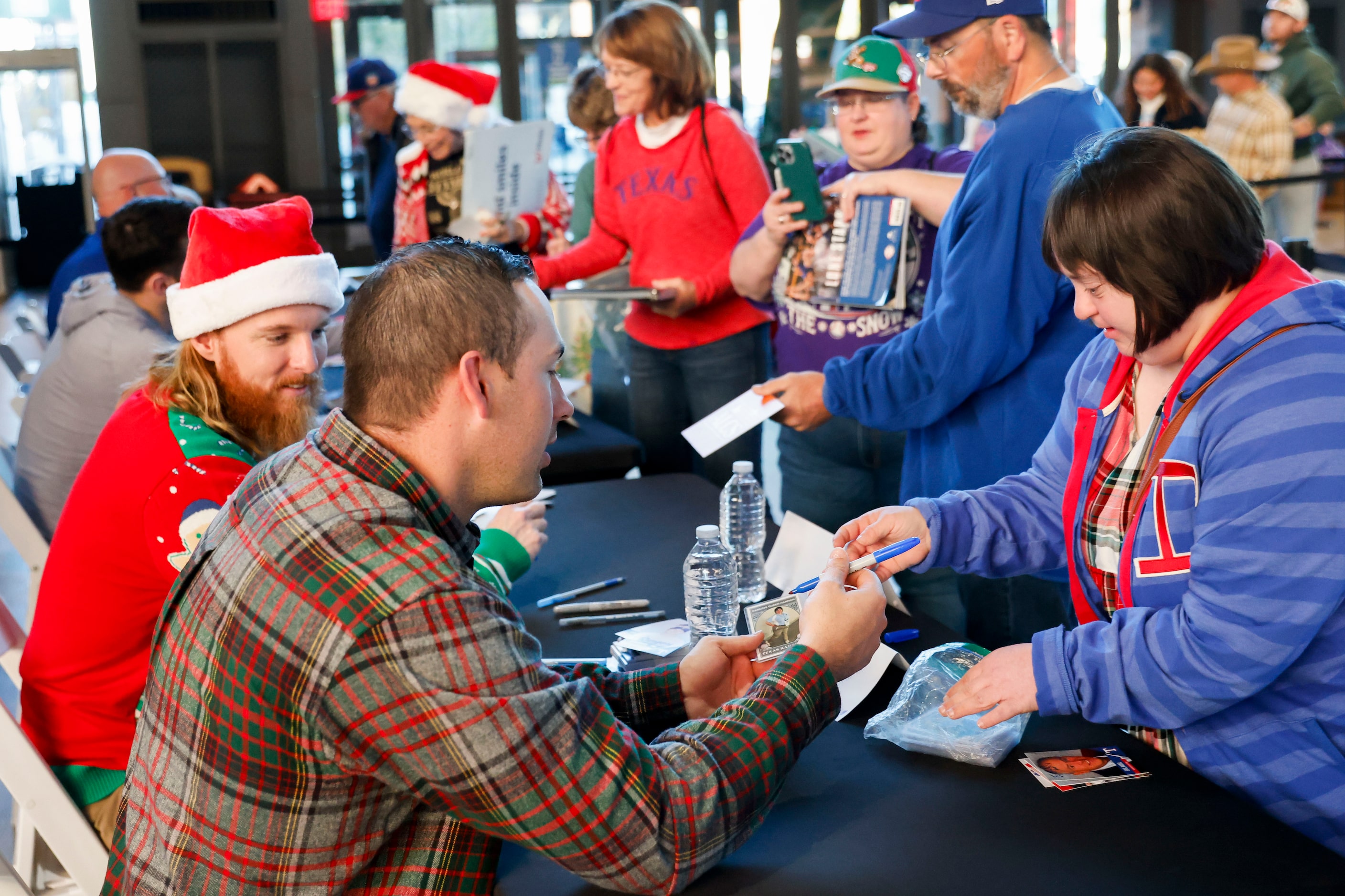 Texas Rangers assistant hitting coach Seth Conner (front) gives autograph to the people...