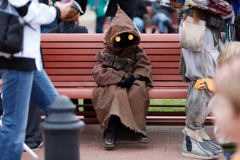 Chay Mullins, 7, dressed as a Jawa, rests on a bench in Celina Square.