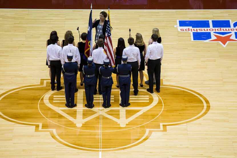 A choir and color guard sing the national anthem before the UIL Class 4A state championship...