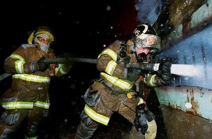 J.V. Smith (left) and Wesley  Pemberton sprayed water into an underground storage facility...