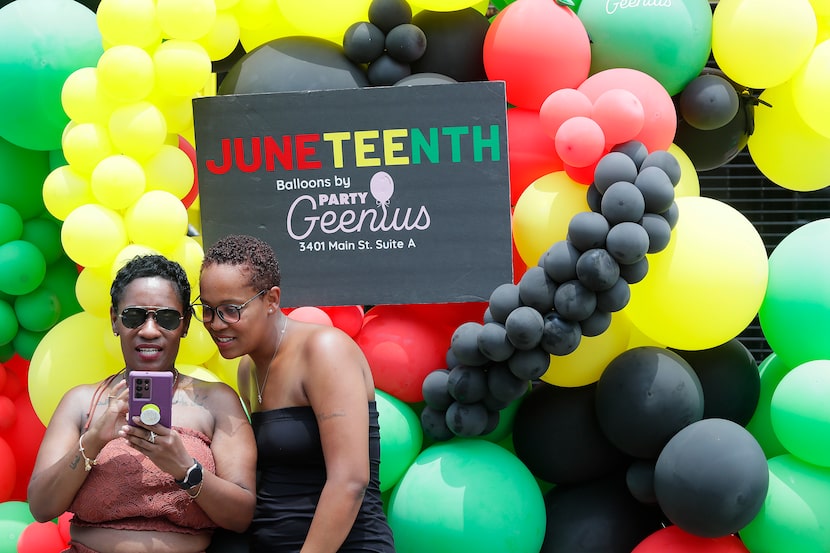 Domino Holmes (left) of Dallas, and Chana Olse, of Ft. Worth, look at phone images in front...