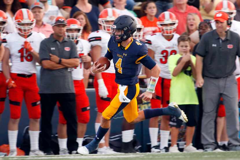 Highland Park quarterback Chandler Morris (4) scampers past the Rockwall bench en route to a...