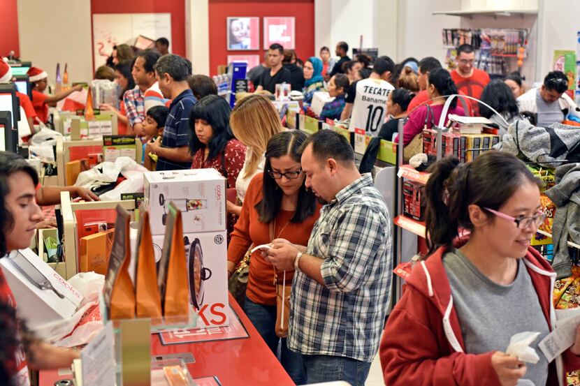 Early Black Friday shoppers, Jazmin Aguilar and Jose Contreras, look at their receipt after...