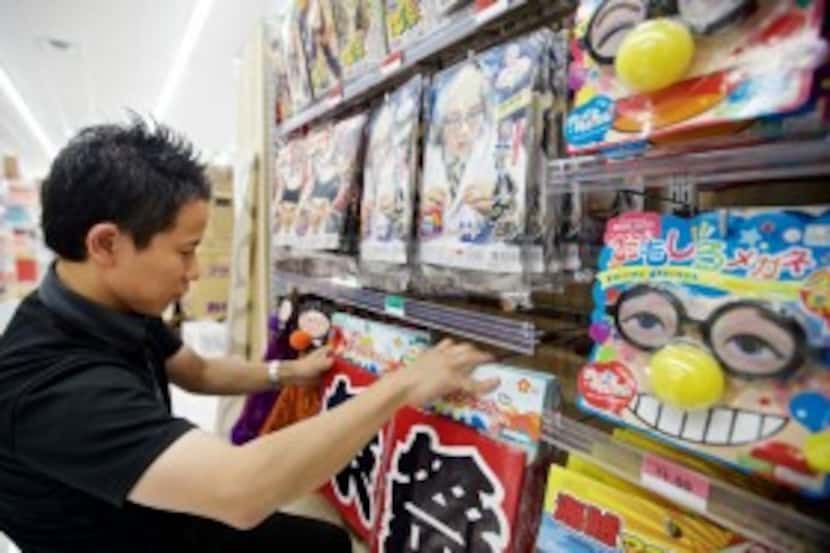  Daiso employee Aki Akira stocks the shelves at the Japanese dollar store in Carrollton....