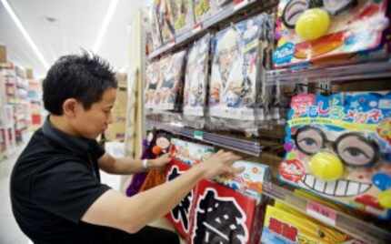  Daiso employee Aki Akira stocks the shelves at the Japanese dollar store in Carrollton....