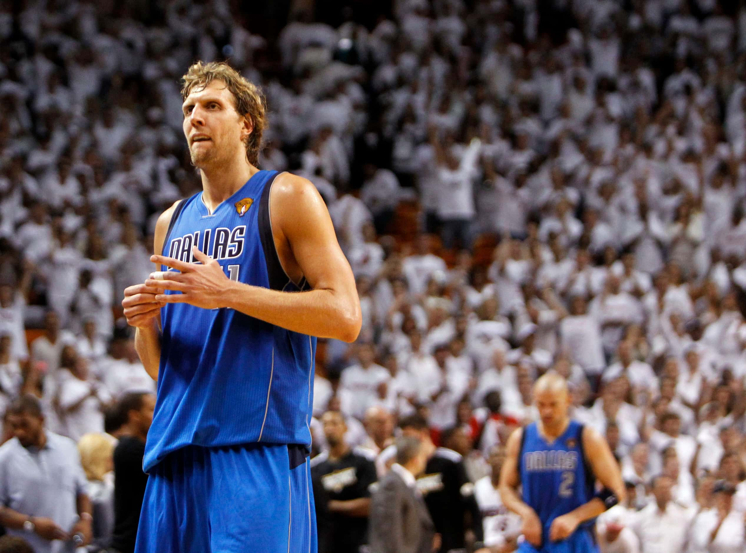 Dallas Mavericks power forward Dirk Nowitzki (41) walks off the court holding his left...