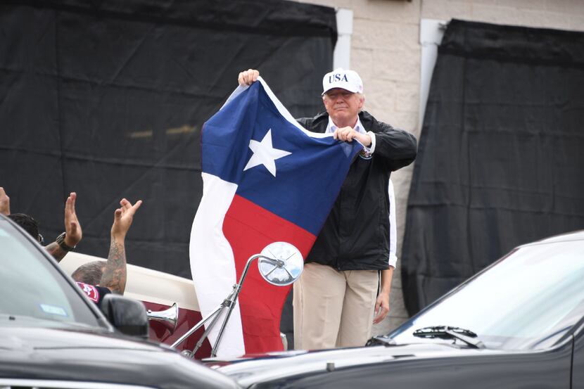 President Donald Trump holds the Texas flag outside of the Annaville Fire House after...