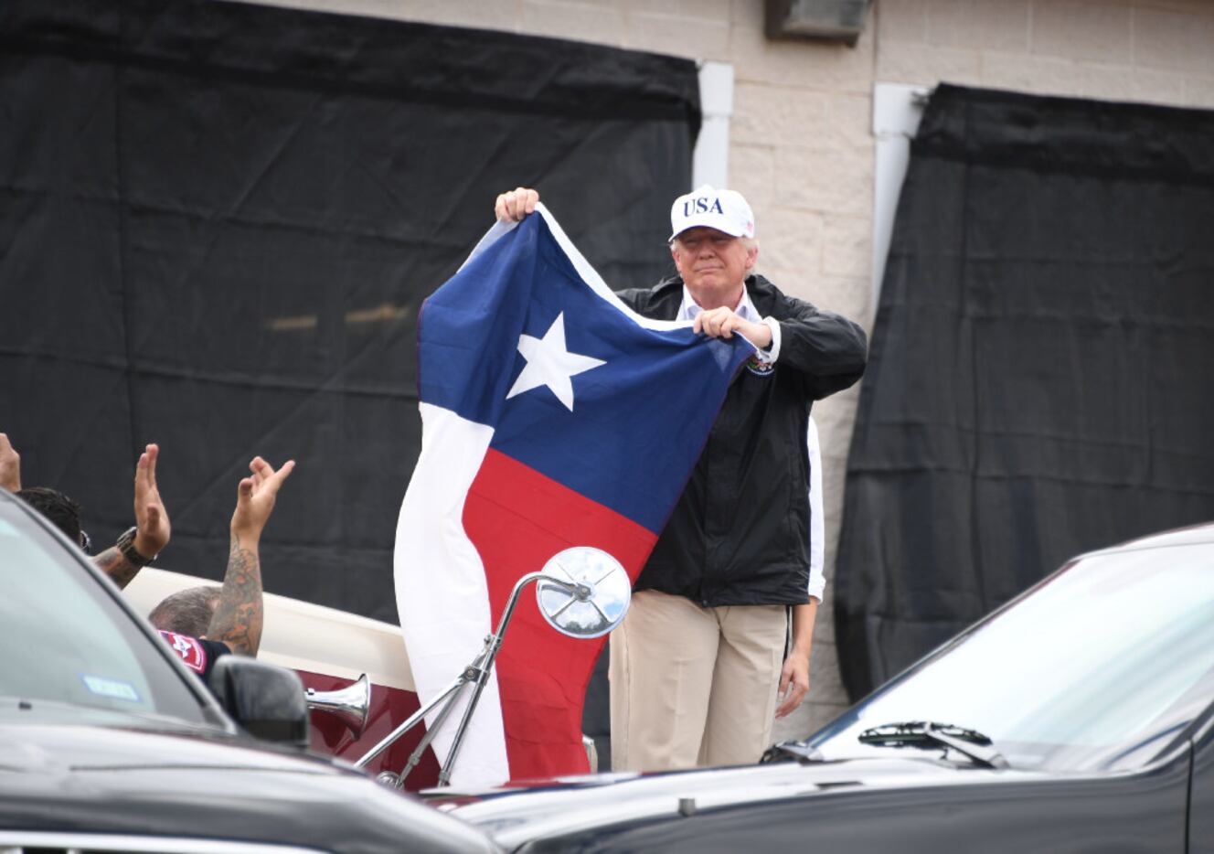 President Donald Trump holds the state flag of Texas outside of the Annaville Fire House...