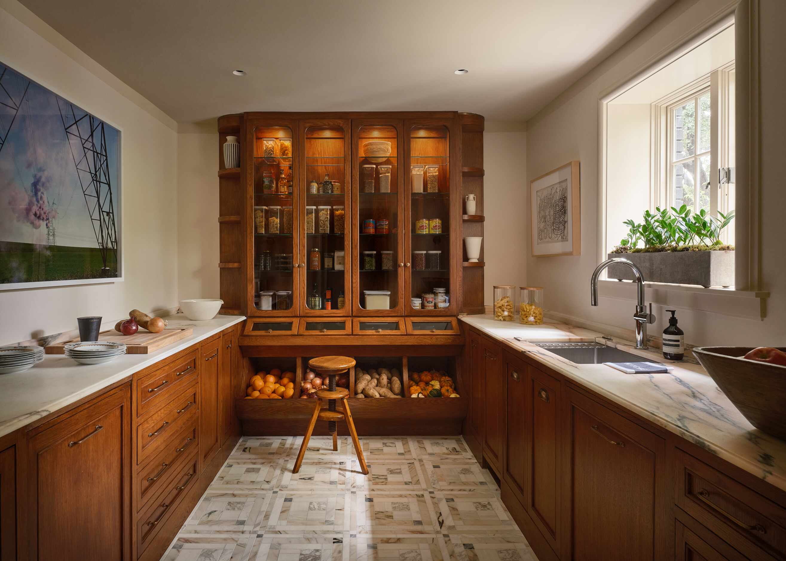 Warm wood cabinetry and glass paneling show off the contents inside, which was designed to...