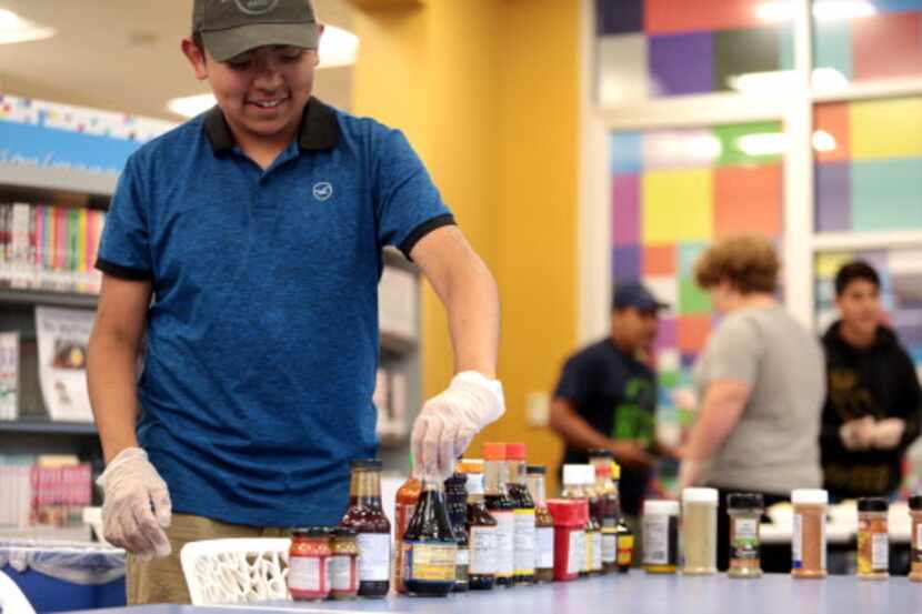 Bryan Vazquez escoge algunas especias durante el Great Ramen Challenge en la biblioteca...