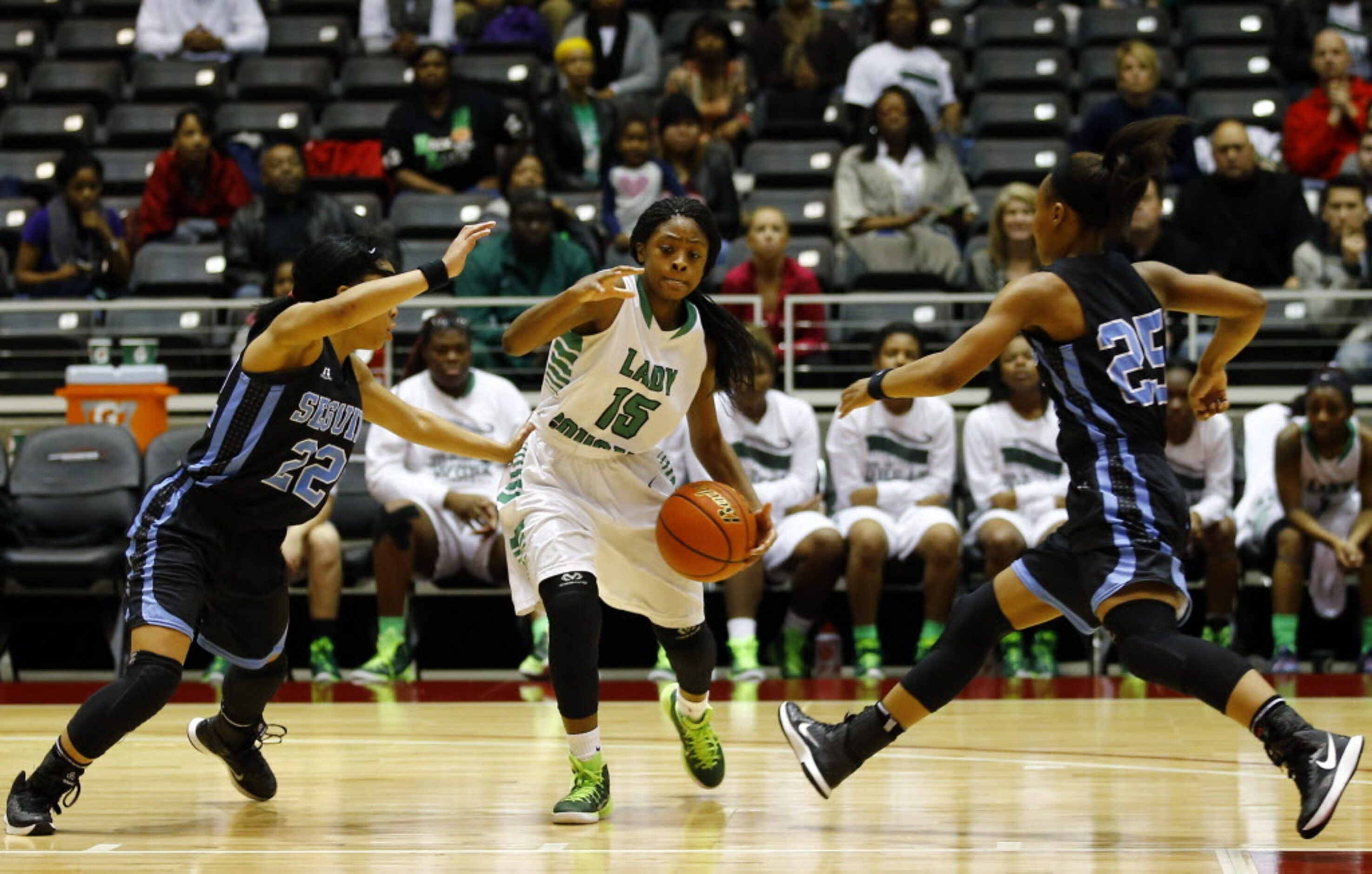 Bryan Adams' DeBrashia Baty (15) drives between Arlington Seguin's Daniese Burton (22)  and...