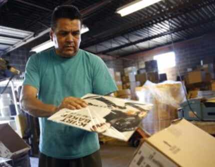  Lazaro Escobar packages a vinyl record at A&R. He too is among the small group of staffers...